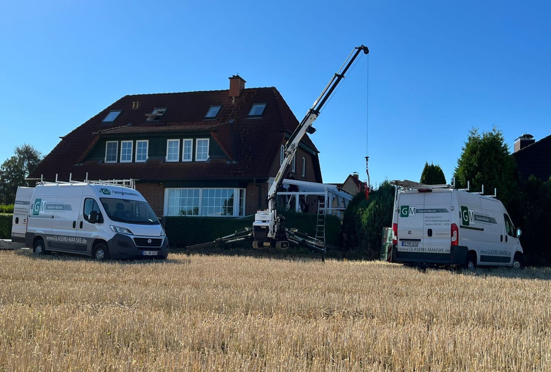 Fensterertüchtigung – Kran und Firmenfahrzeuge vor Wohnhaus